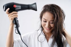 woman drying long hair with a hairdryer