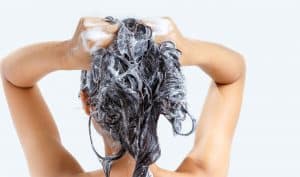 Woman washing hair with shampoo