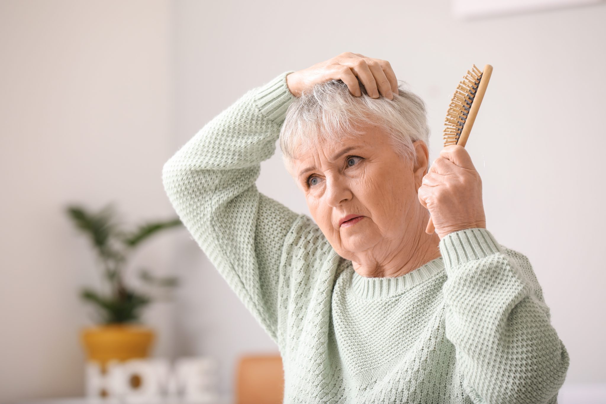 Senior woman with hair loss problem at home
