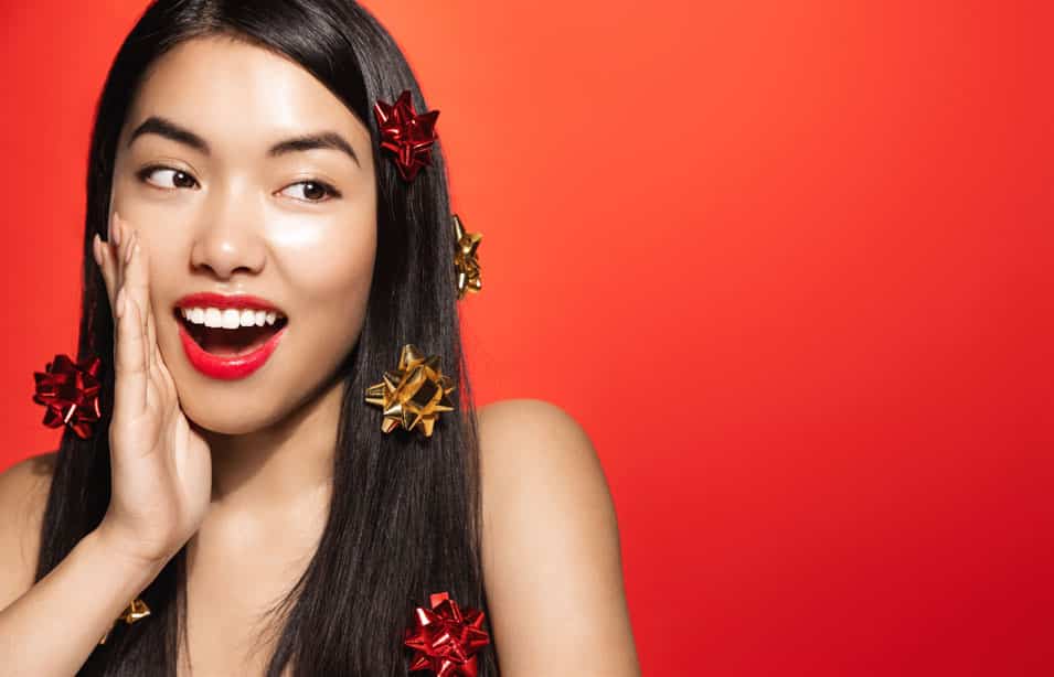 Asian girl with holiday christmas gift wrap on hair