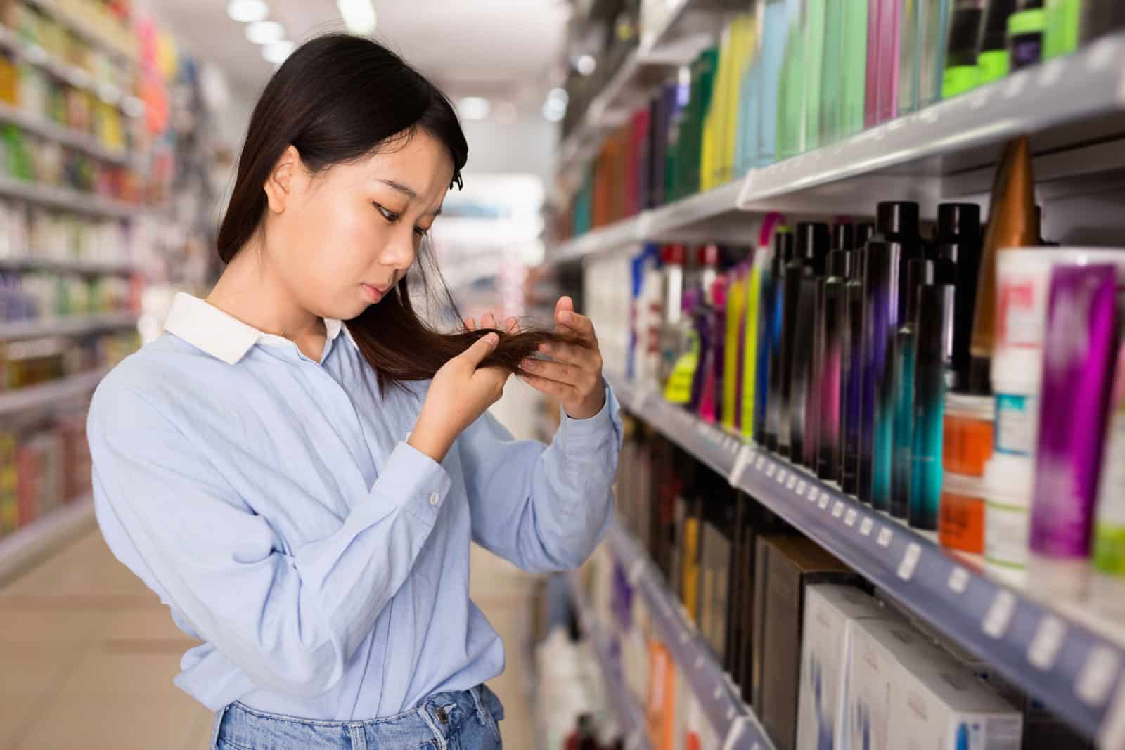 woman choosing hair products and checking her hair